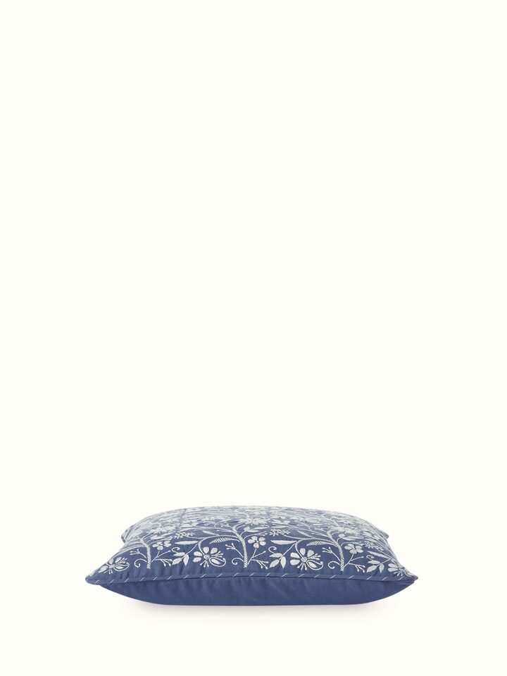 Angled view of blue cushion highlighting fine Chikankari craftsmanship.