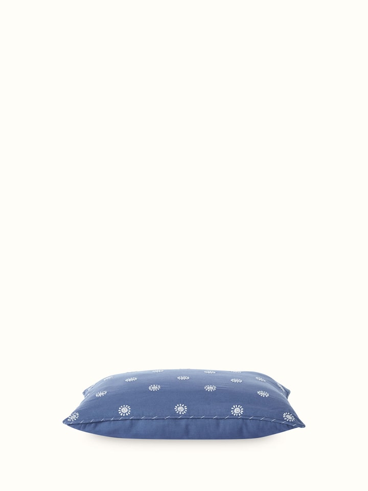 Angled view of lumbar cushion showing compact size and embroidery details.