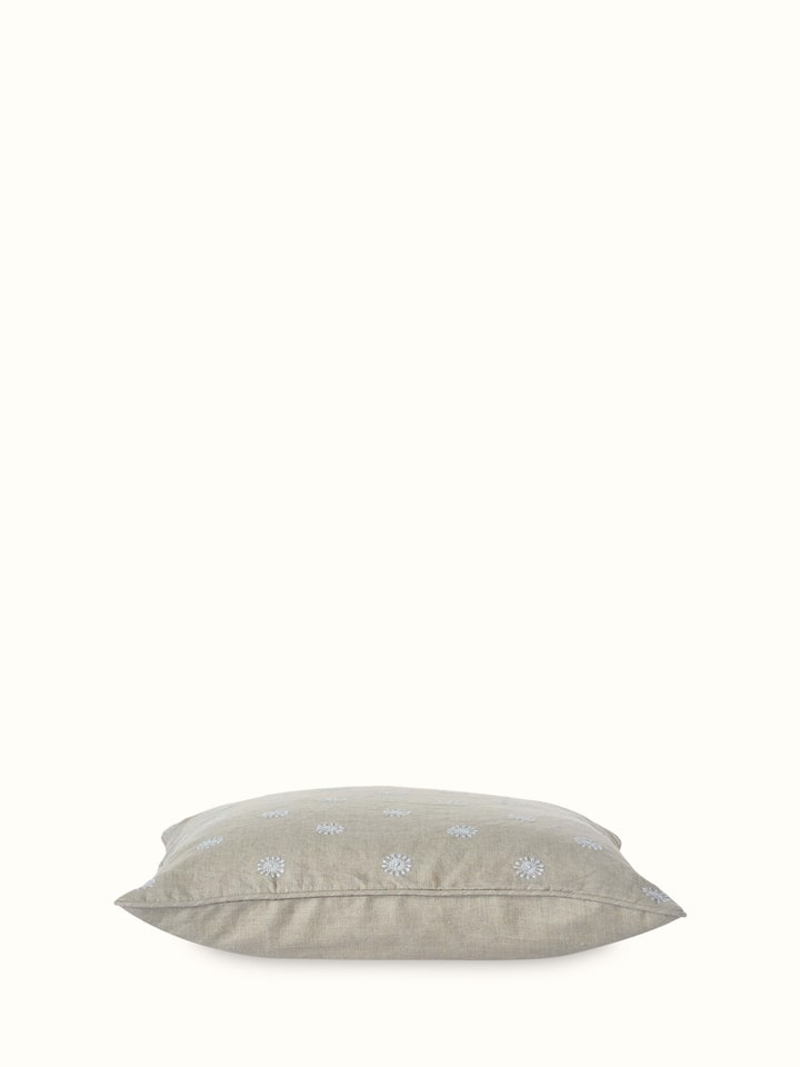 Angled view of Rann cotton cushion cover displaying intricate floral Chikankari work