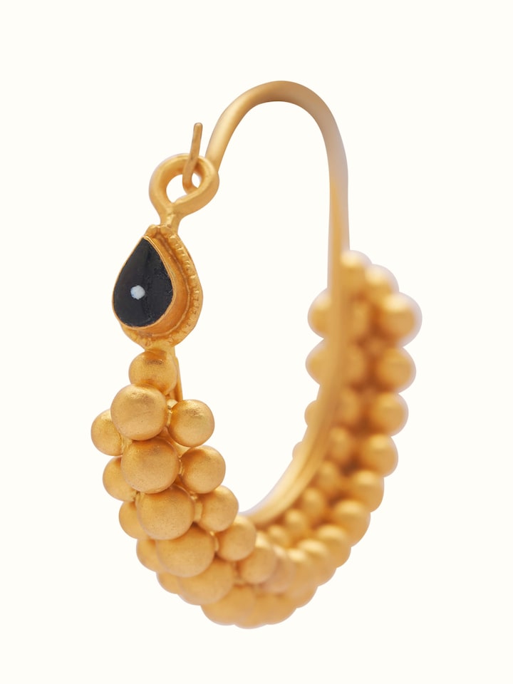 Angled view of gold hoop earrings showcasing circular handcrafted form and embossed texture