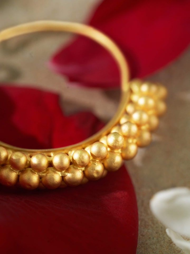 Close-up detail of gold hoop earrings highlighting fine goldwork and traditional finish