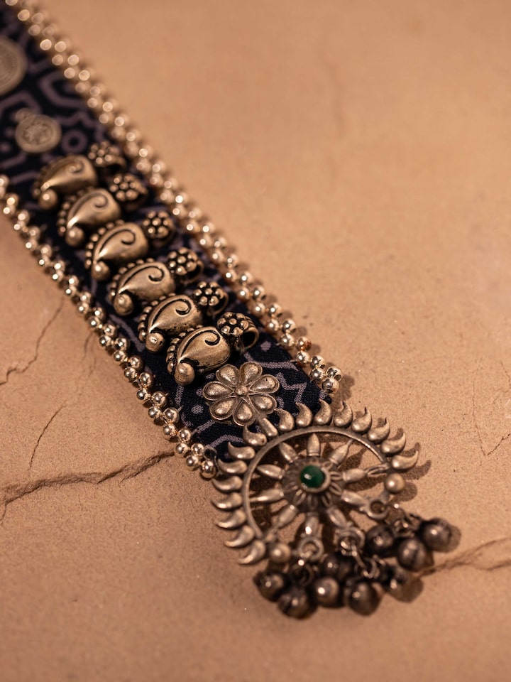 Detail shot of the necklace’s pendant and thread finishing