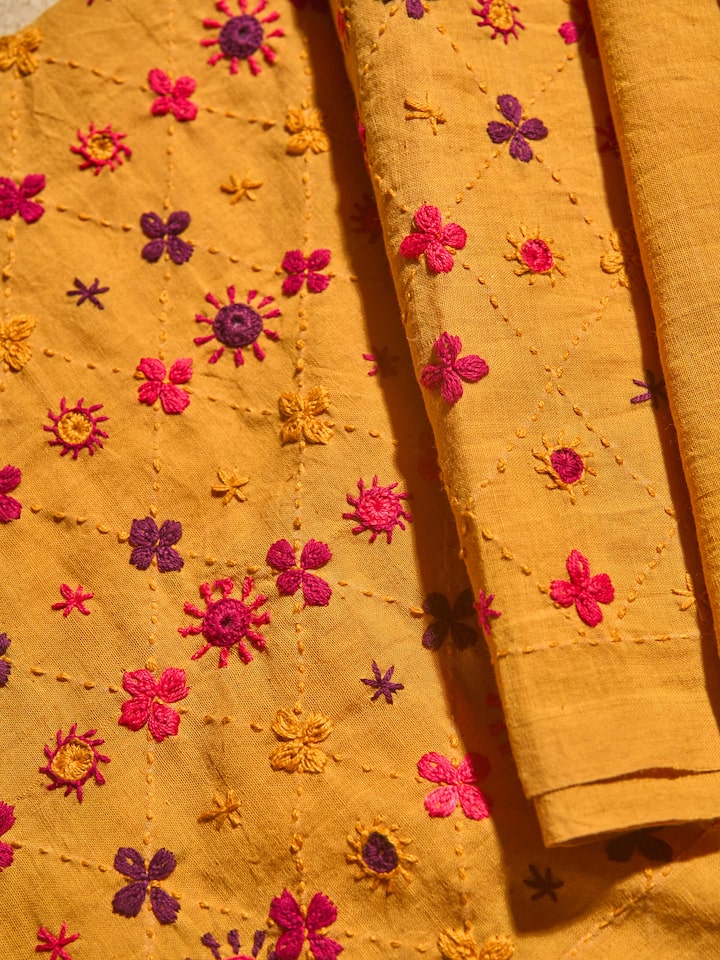 Close-up detail of colorful Lambani embroidery on blouse fabric.