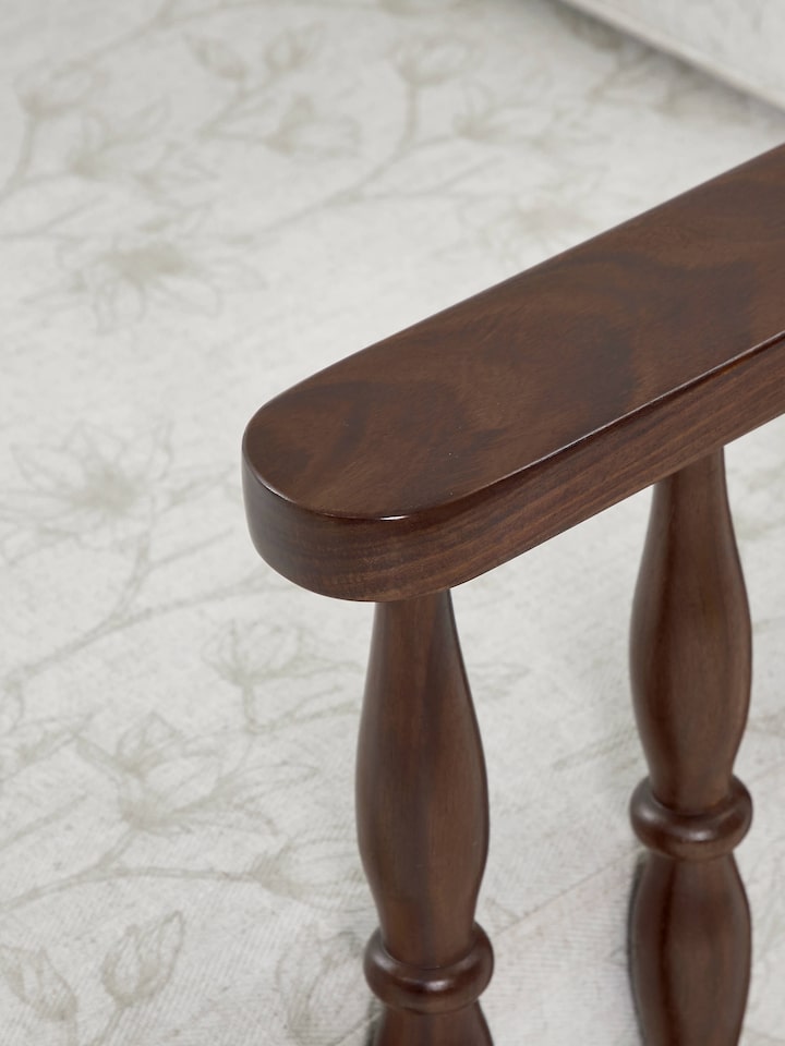 Back view of the teak finish upholstered sheesham wood 1-seater sofa, showcasing its smooth wood finish and sturdy construction.