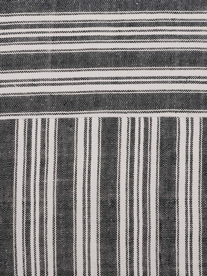 Ujjal black kaya cotton handloom cushion cover displayed on a sofa, demonstrating its practical use and elegant look.