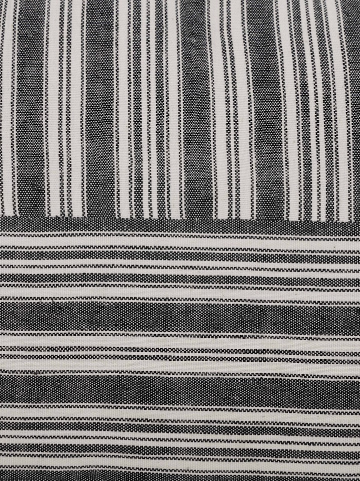 Perspective view of Krsna black kaza cotton handloom cushion cover showcasing the overall design and handloom texture.
