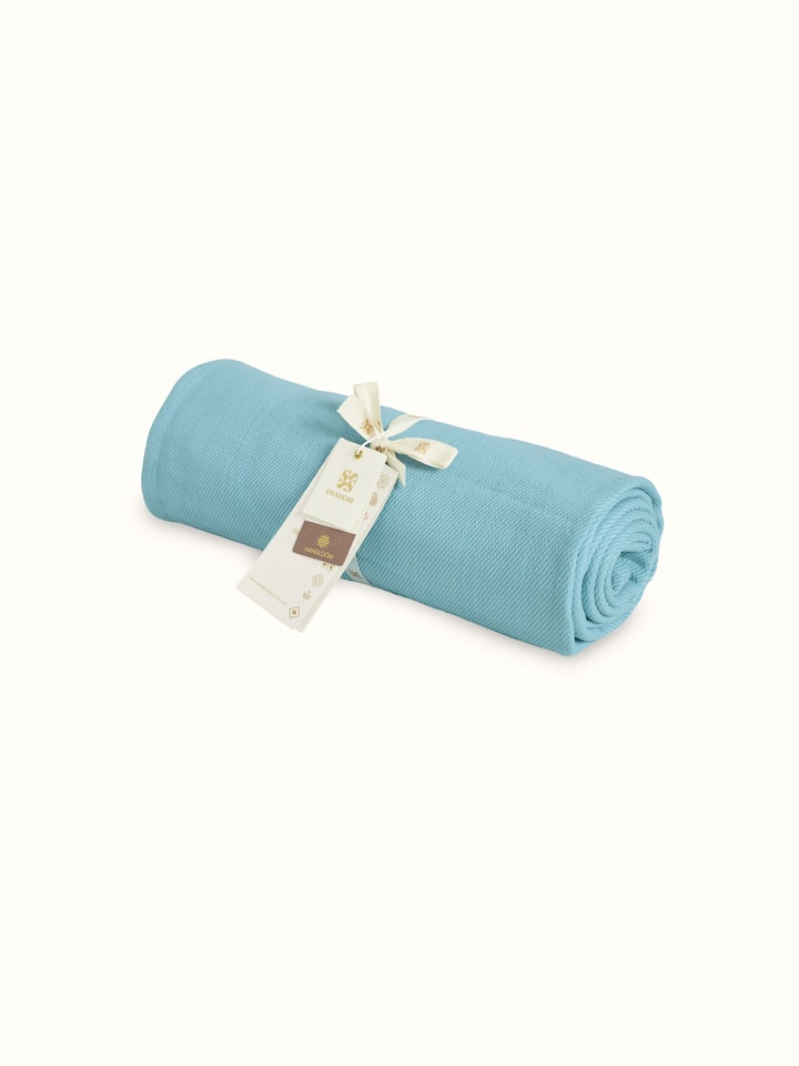 Angled view of Tavas turquoise twill cotton handloom throw displaying the color and texture details