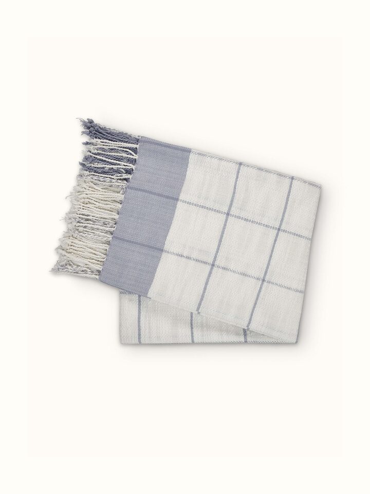 Lifestyle shot of Adhima grey twill cotton handloom throw in a cozy setting