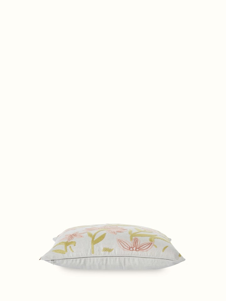 Angled view of Mansur peach jaal linen crewel hand-embroidered cushion cover displaying the intricate embroidery work