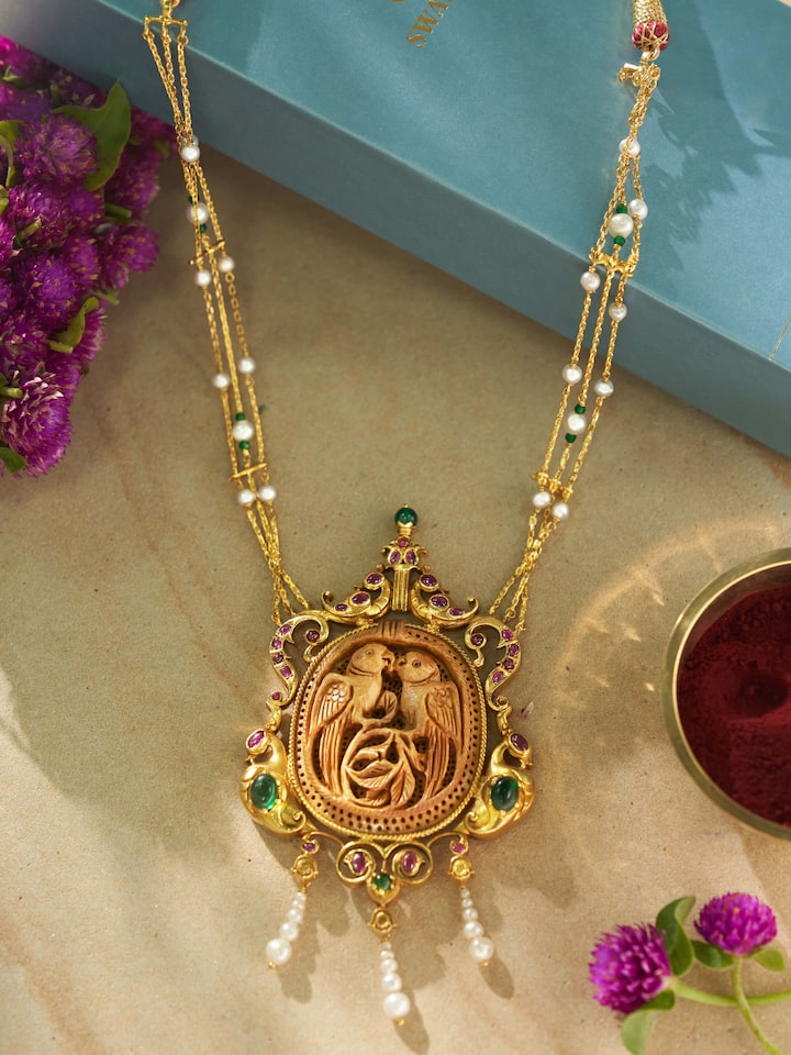 Close-up of carved wood & silver long necklace emphasizing fine carvings and details