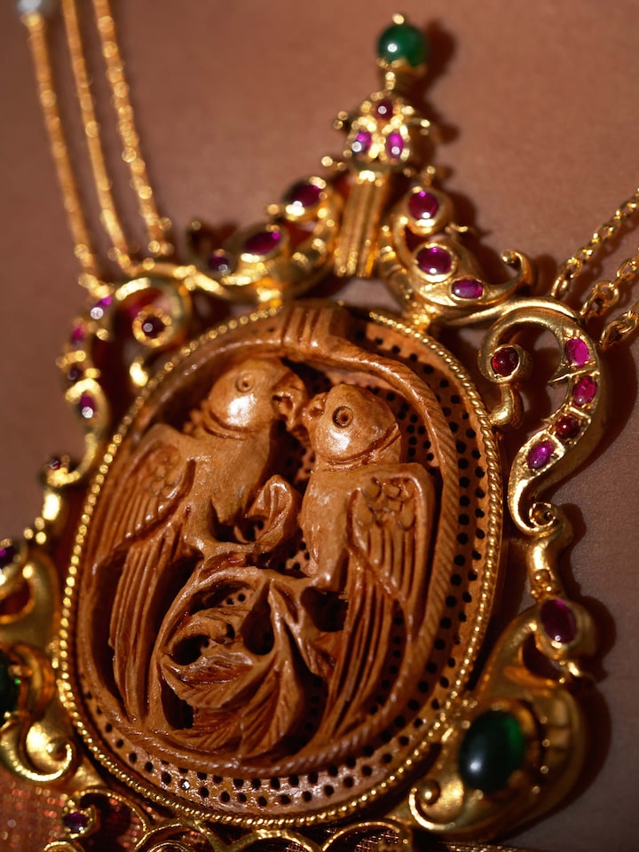 Detailed shot of carved wood & silver long necklace focusing on intricate carvings and elegant design