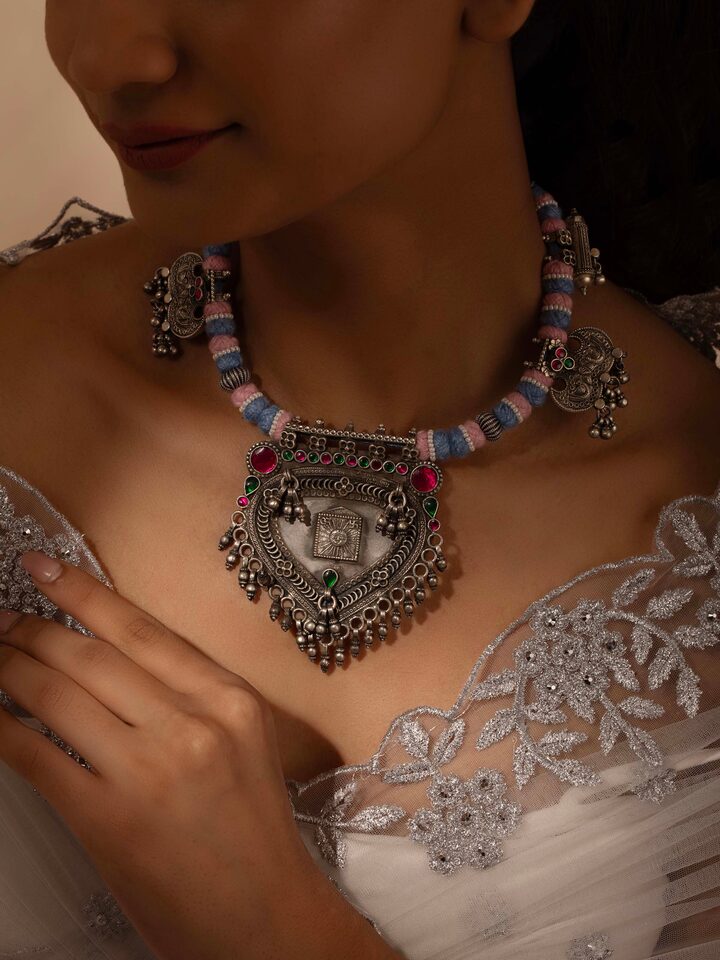 Side view of silver smithing collar necklace showing its design and elegant curve