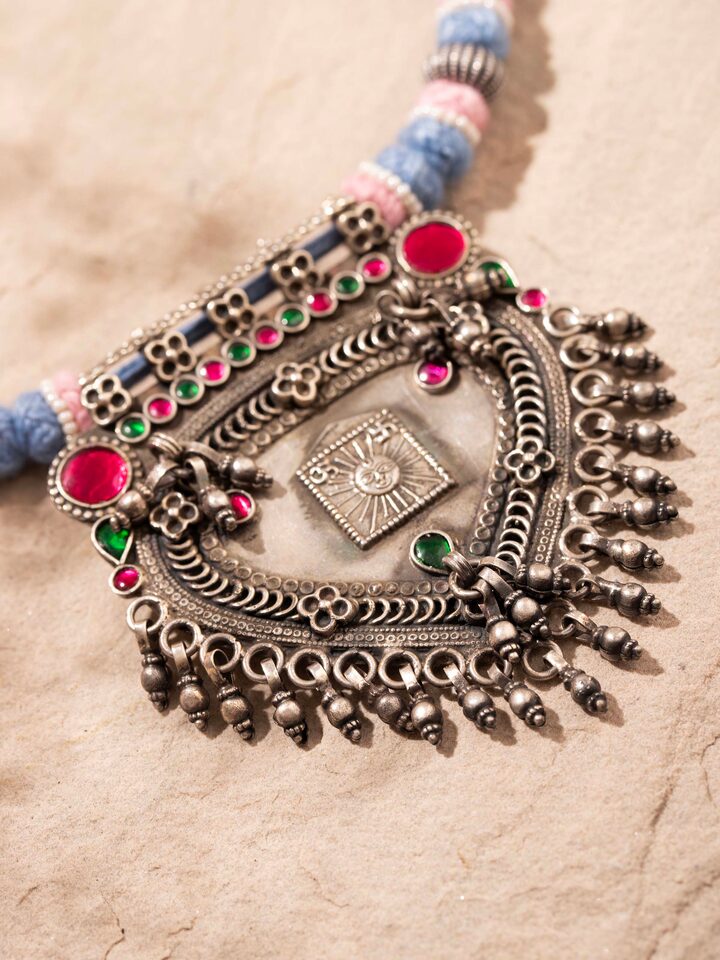 Detailed close-up of silver smithing collar necklace showcasing texture and shine