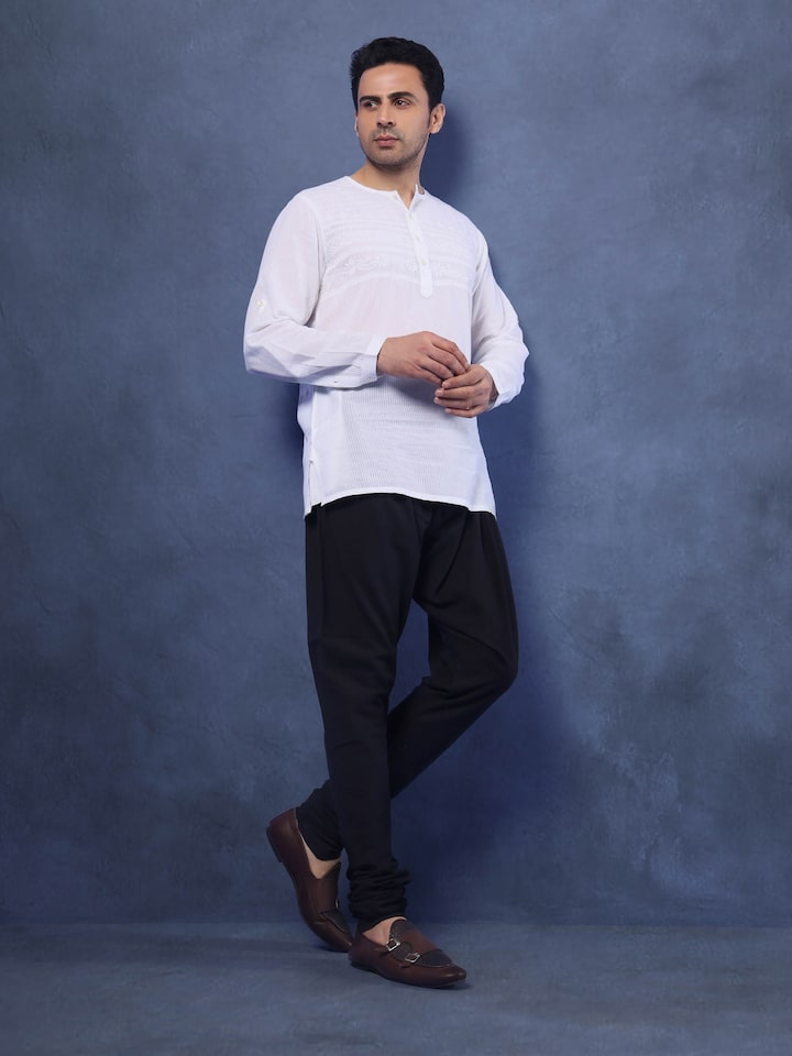 Model wearing black churidar with kurta in a casual ethnic setting.