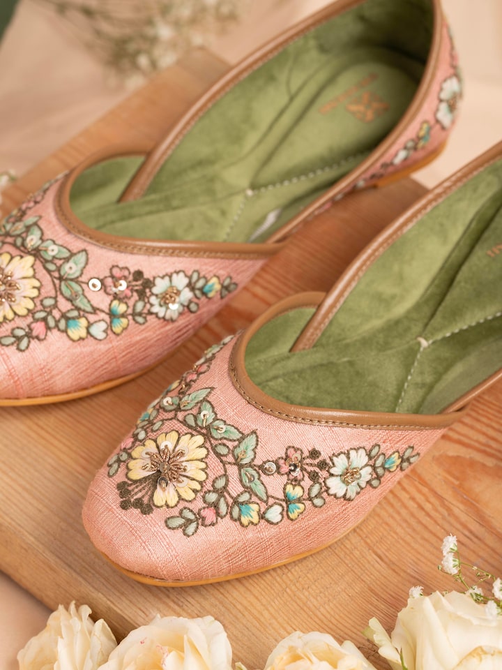 Close-up of pink leather zardozi juttis emphasizing the fine zardozi work
