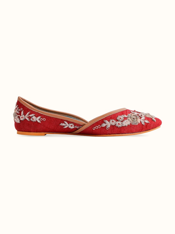 Angled view of maroon leather zardozi juttis emphasizing design and craftsmanship
