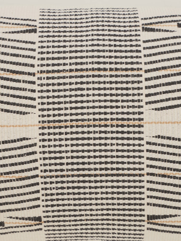 Ridhama white Kalinda cotton Naga handloom cushion cover in a setting, emphasizing its style and design.