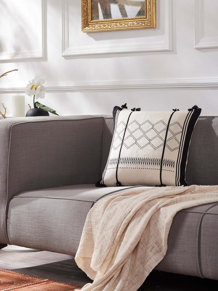 Lifestyle view of Ridhima ivory cushion cover adding a handcrafted touch to contemporary decor