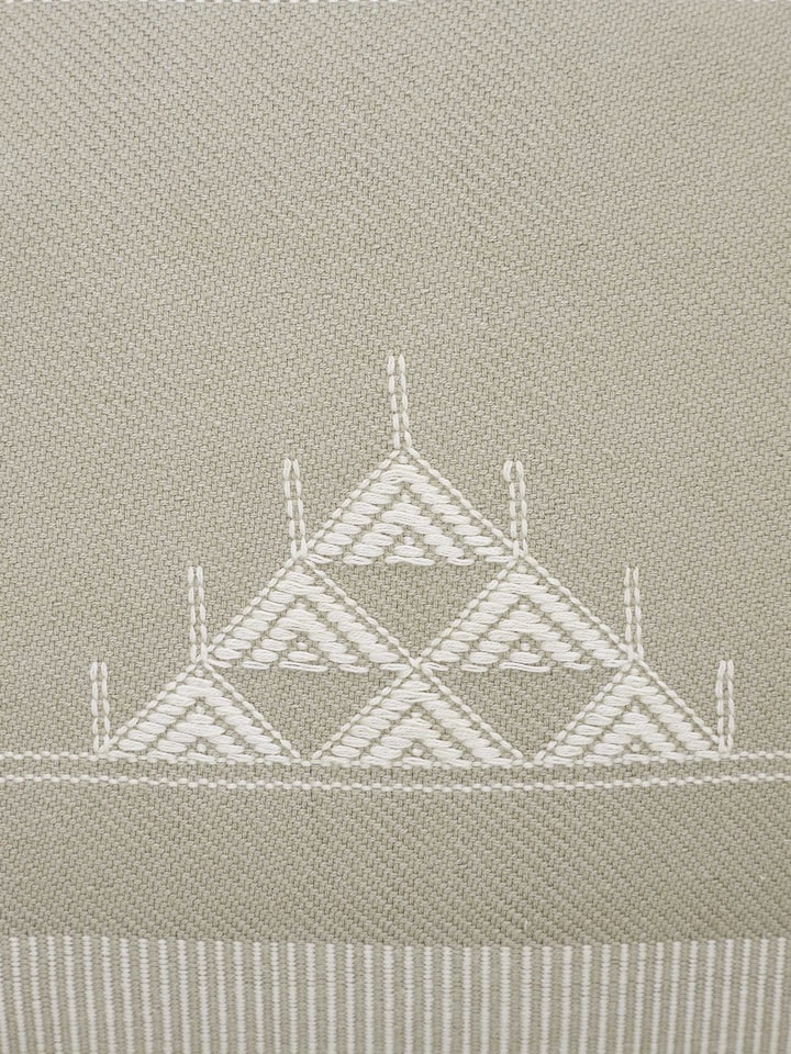 Artistic view of Godna light beige triangular stripe cotton handwoven pattu cushion cover in a room setting