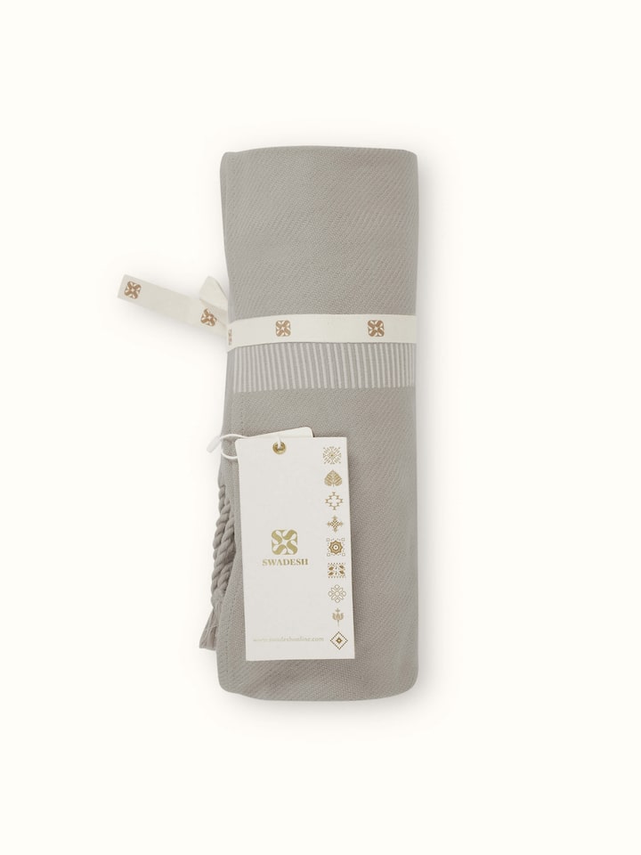 Close-up showing detailed handwoven cotton texture and neat stripe design of the throw.