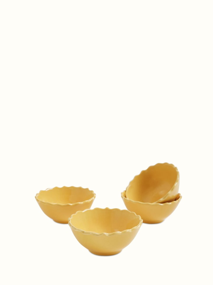 Angled view of Khurja pottery ceramic dinner bowls in yellow, set of 4, emphasizing the intricate design details.