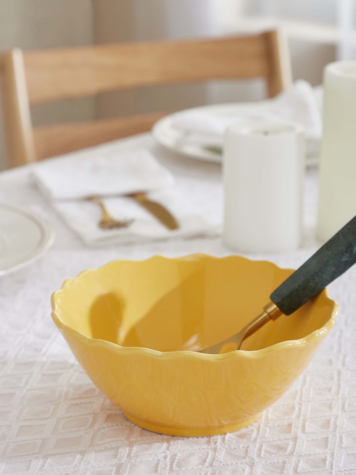 Side view of Khurja pottery ceramic serving bowl in yellow, highlighting its shape and glaze details.