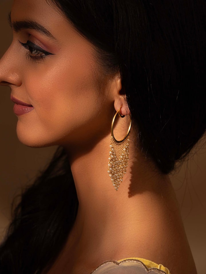 Close-up view of silver smithing hoops showcasing detailed design and craftsmanship