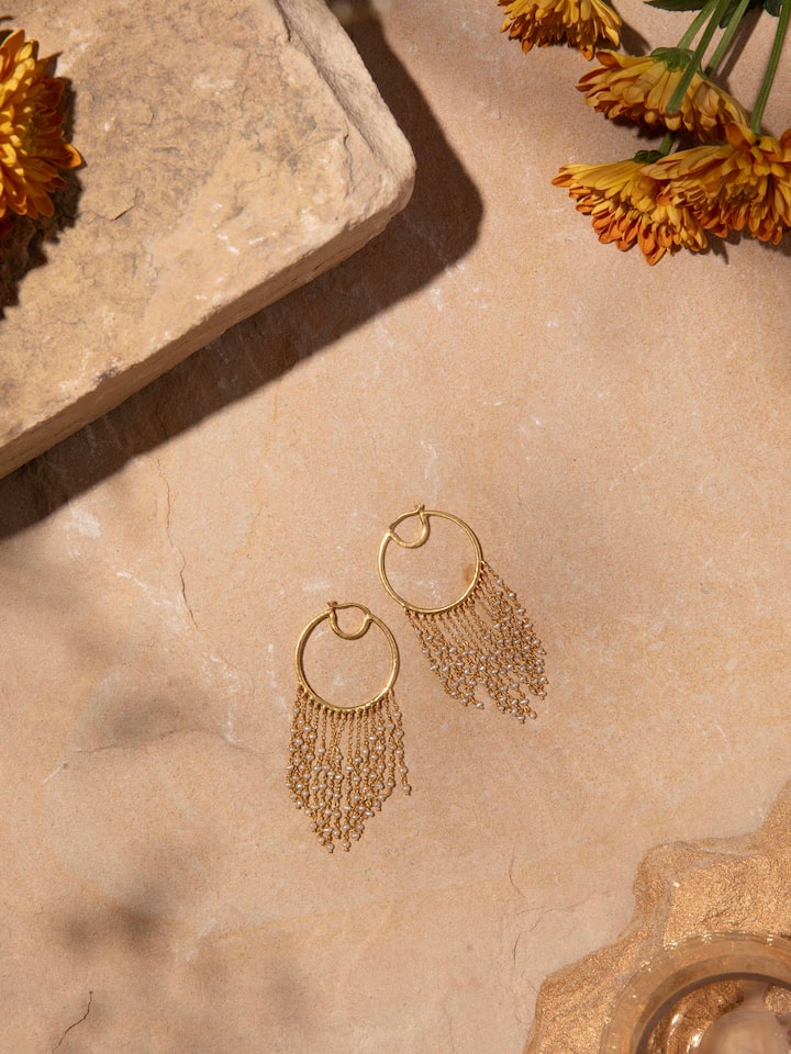 Angled view of silver smithing hoops emphasizing their detailed design and shiny finish