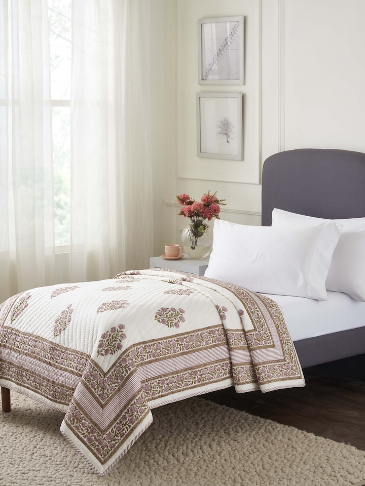Lifestyle view of Saha lavender Buta cotton quilt featuring Sanganeri hand block print in single size, styled on a wooden bed.