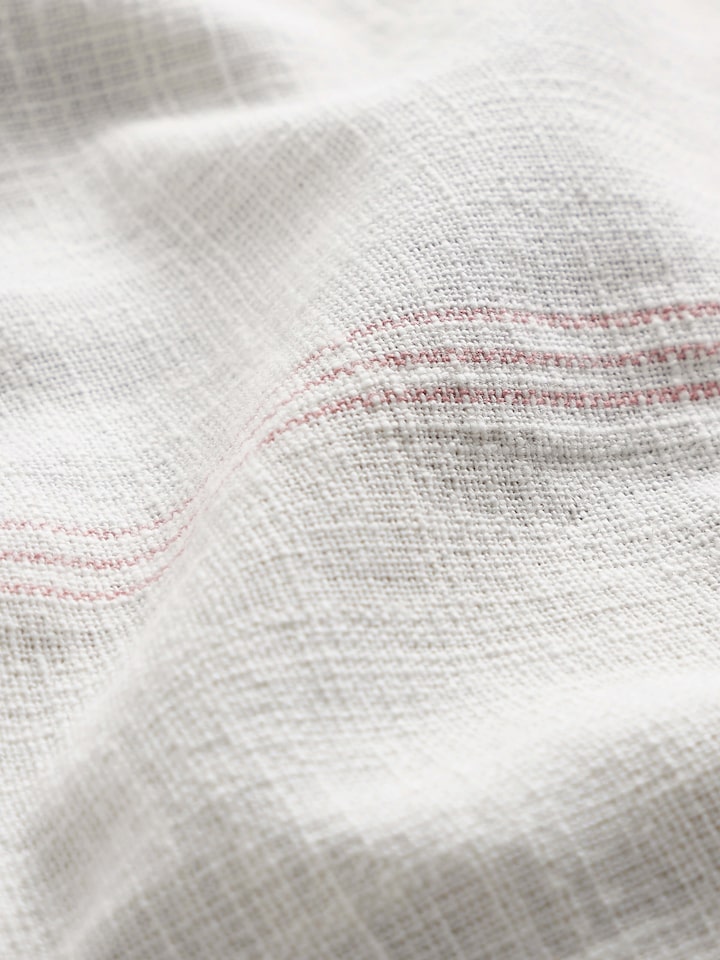 Side view of Arth pink stripe cotton table cover (4 seater) showing the drape and edge details
