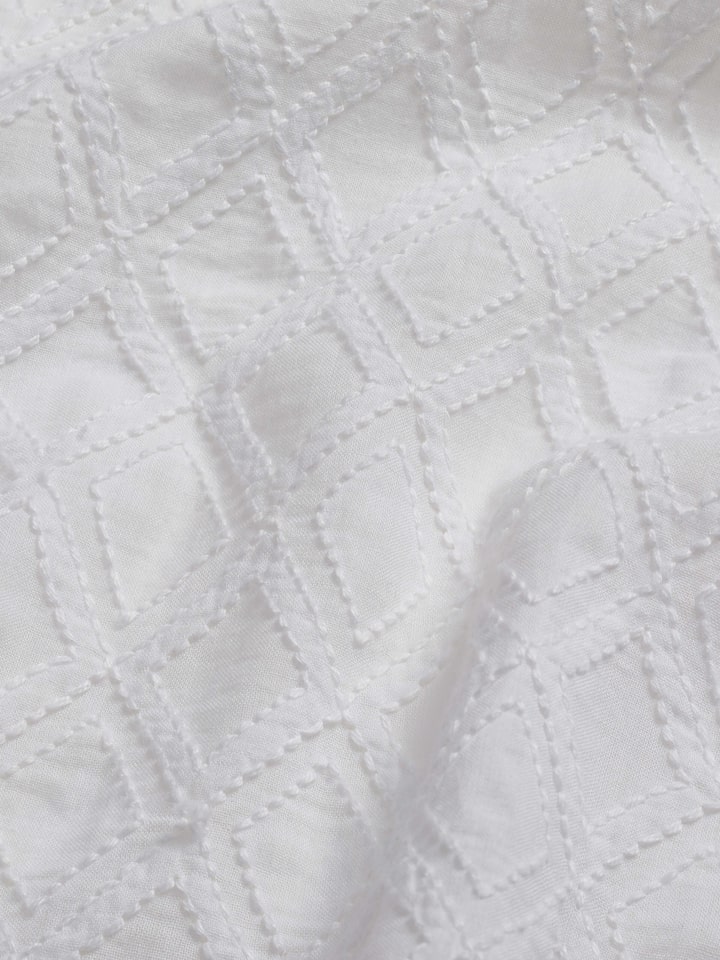 Full view of Ananda white geometric cotton Chikankari table cover (4 seater) showing the elegant design and use on a table.