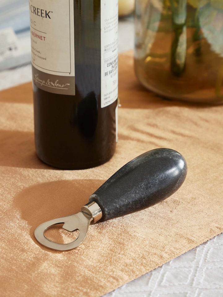 Close-up of the marble and stainless steel bottle cap opener highlighting its modern design.