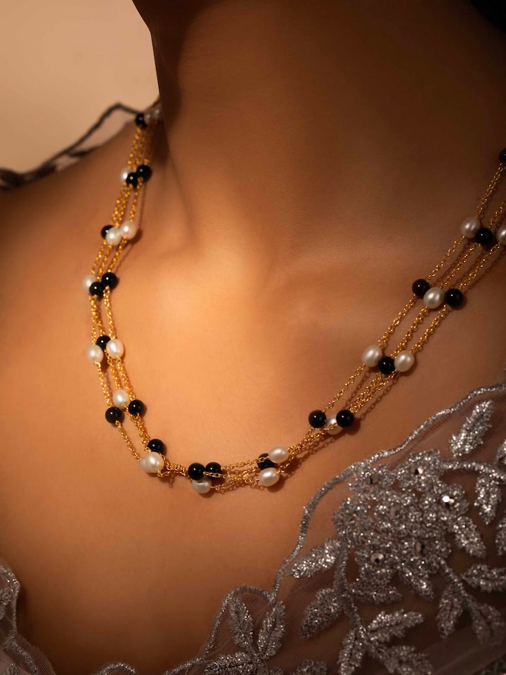Styled detail view of Gemstone Strings Silver Long Necklace worn on the finger, shown in another styled shot