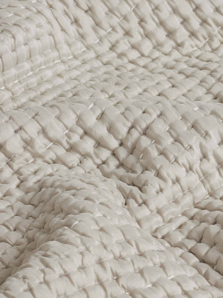Ahilya grey textured silk razai embroidered double bedspread set displayed on a bed, showing its full design and use.