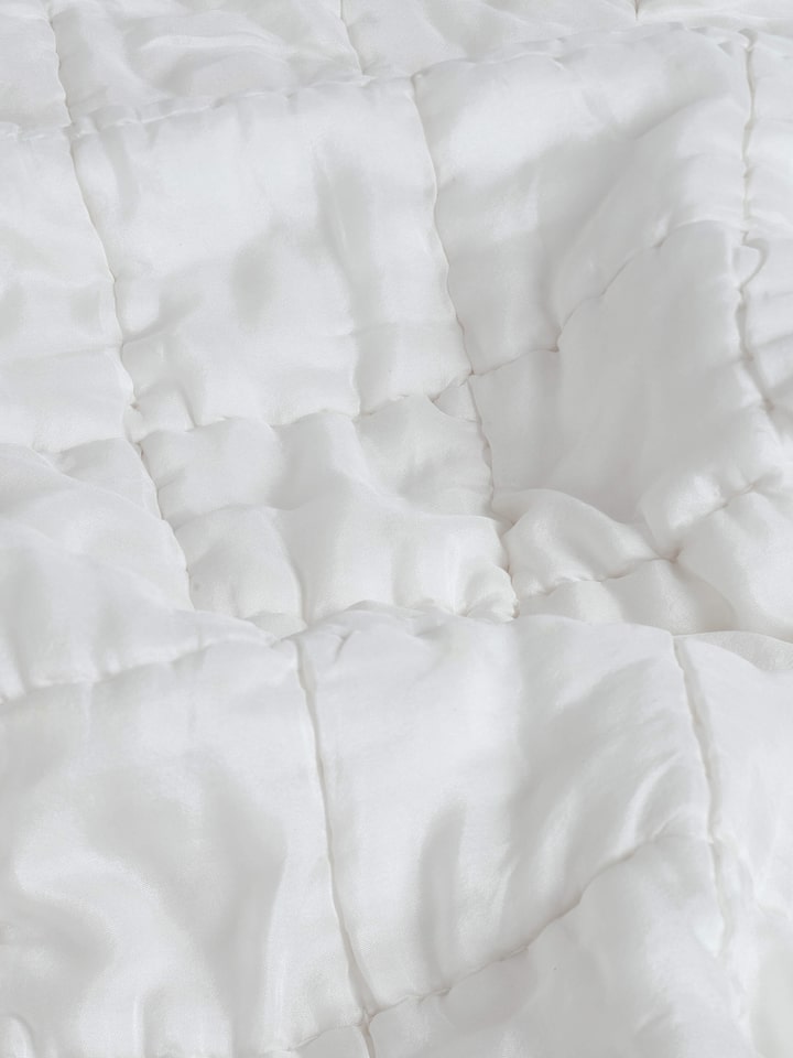 Pipa ivory solid silk razai embroidered double bedspread set (3 pcs) shown in a setting, highlighting its luxurious appearance.
