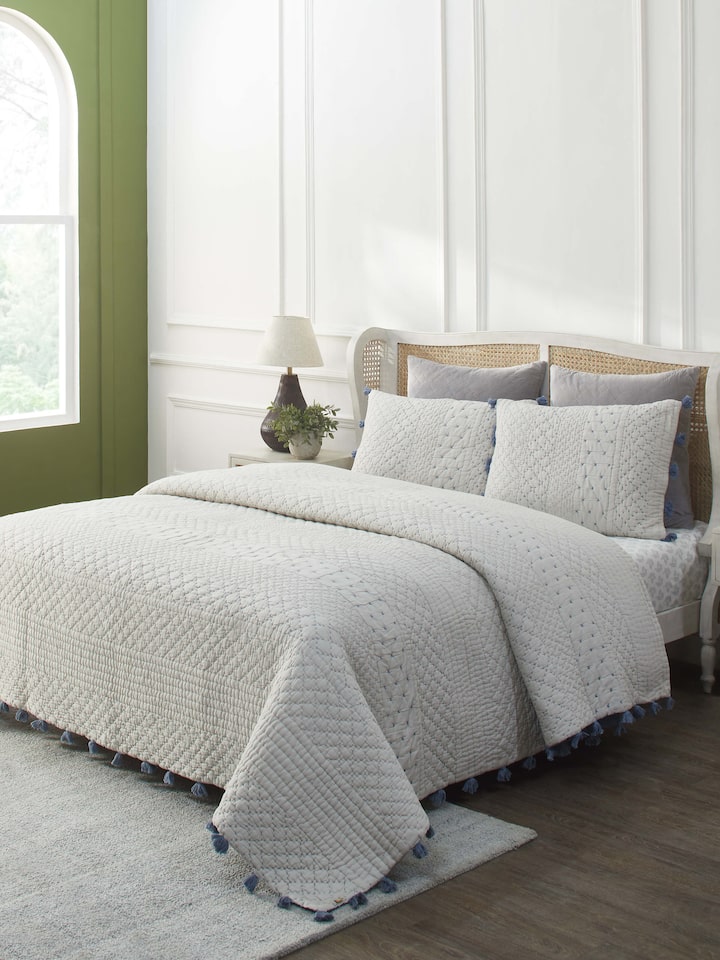Lifestyle image of Nitya Blue Textured Stripe Cotton Razai Embroidered Double Bedspread Set in a bedroom setting.