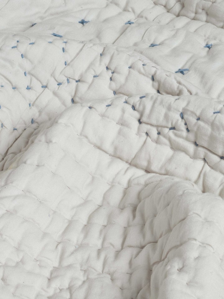 Nitya Blue Textured Stripe Cotton Razai Embroidered Double Bedspread Set folded, emphasizing the embroidery and texture.