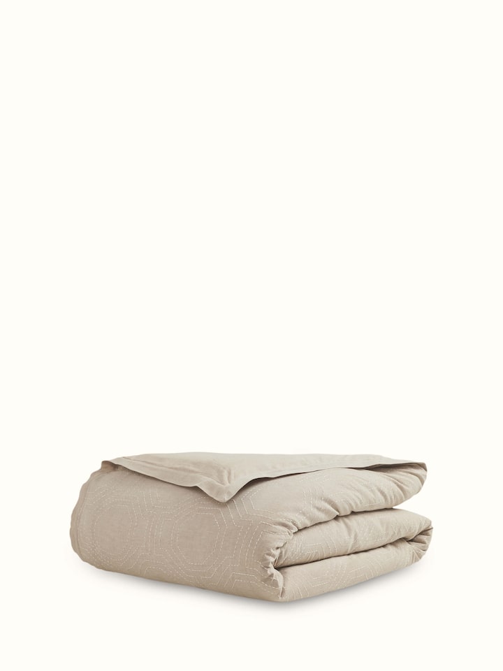 Kahani brown geometric cotton duvet cover with Kantha embroidery, displayed on a bed to highlight intricate stitching and design.