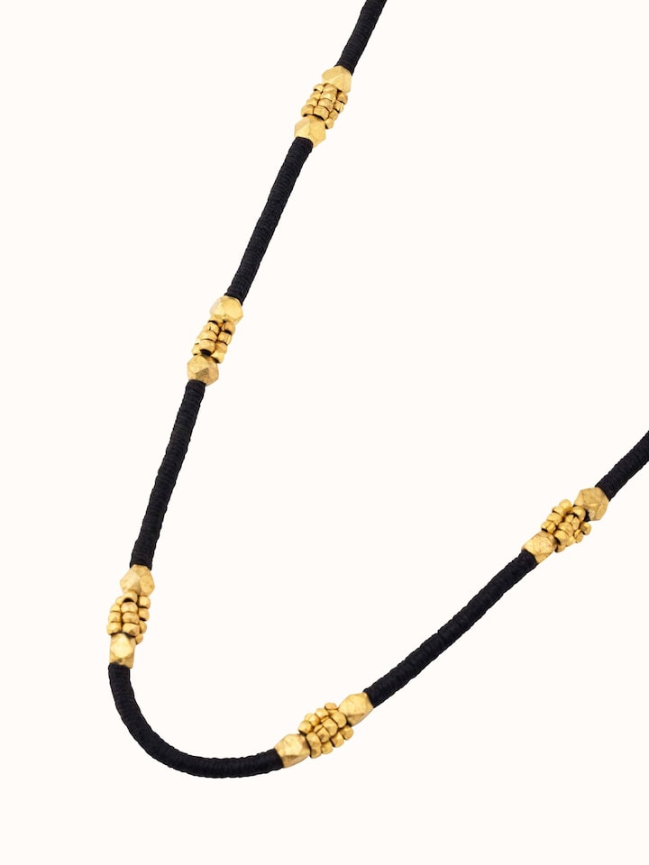 Overhead view of Dhokra Long Necklace displaying intricate design patterns