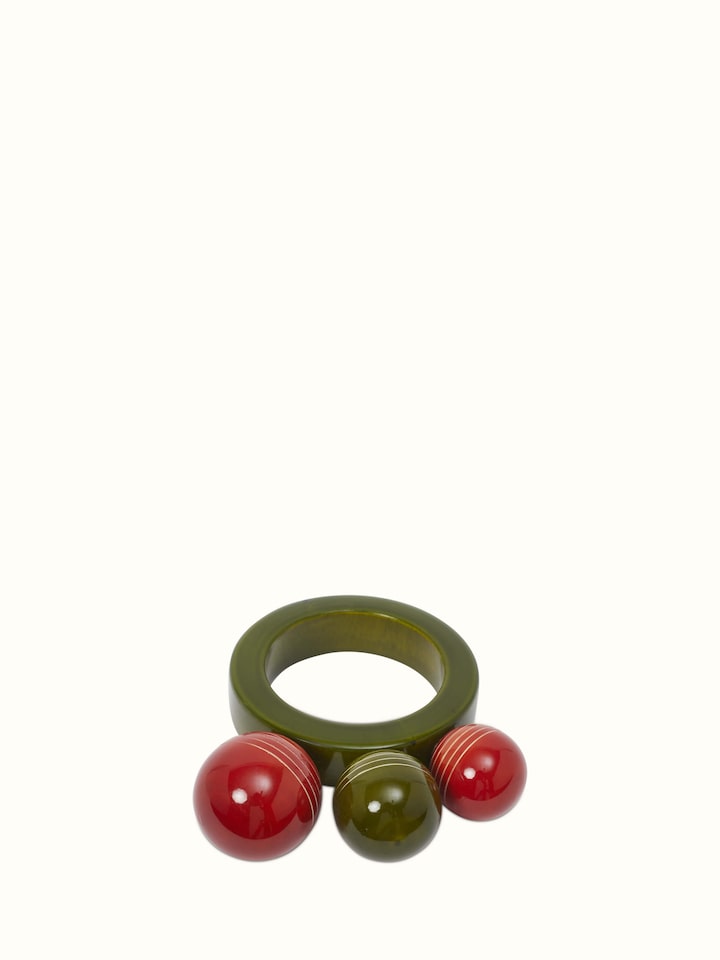 Close-up of Channapatna ivory wood ball ring rattle toy, highlighting the intricate craftsmanship and color.
