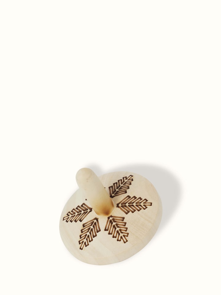 Close-up of Channapatna Ivory Wood Spinning Top Toys in Off-White showcasing fine craftsmanship.