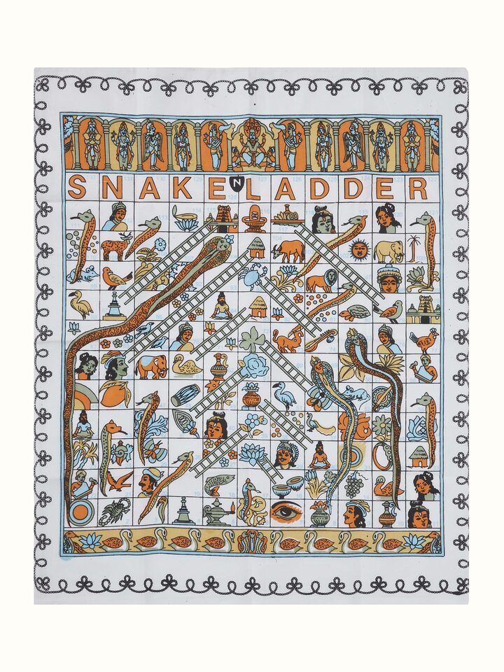 Close-up of Channapatna ivory wood snake and ladders board game in white