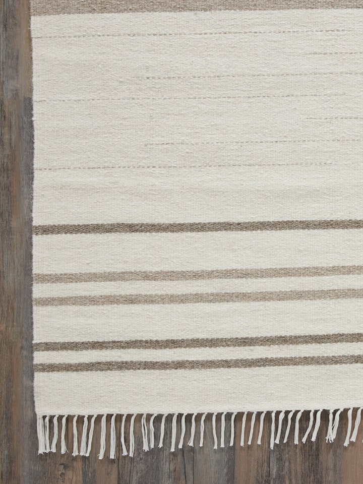 Perspective view of Nomad Stripes Ivory Beige Jawaja wool & cotton handloom dhurrie displaying the overall stripe design and color.