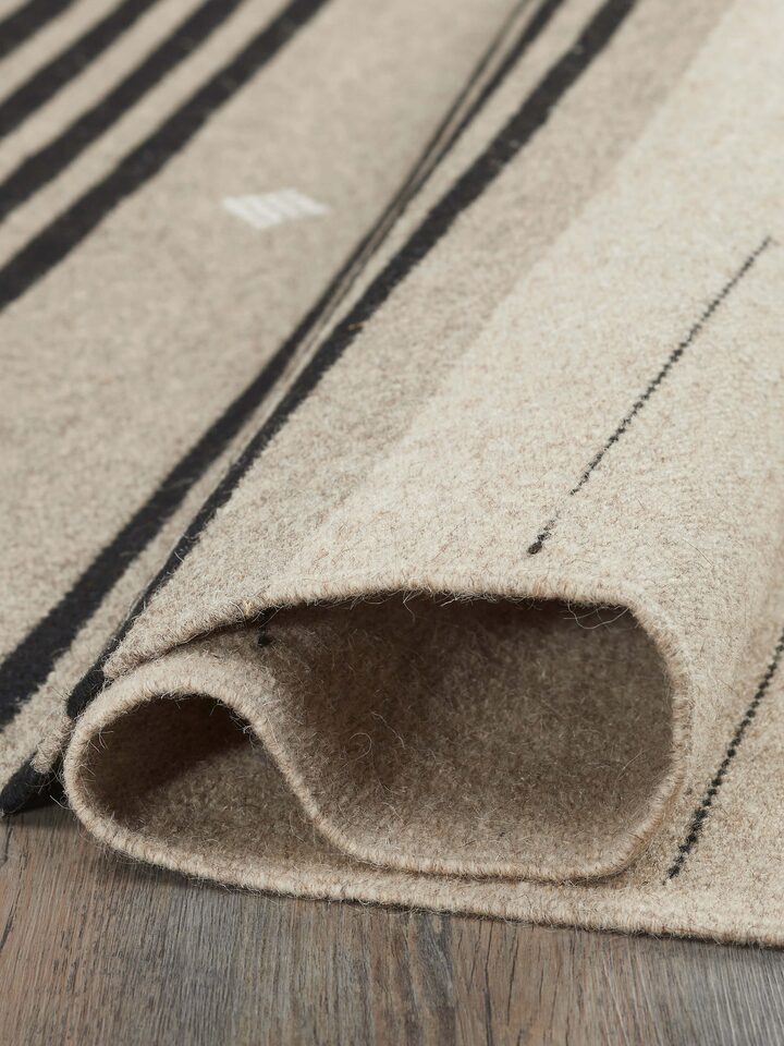 Nomad stripes beige black Jawaja wool & cotton handloom dhurrie (4x6 ft) folded to show the fabric and stripe pattern details.