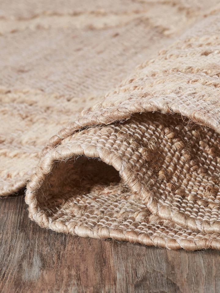 Contemporary geo beige jute & cotton natural fibre rug (5x8 ft) displayed in a setting, emphasizing its design and size.