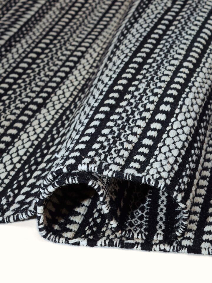 Detailed view of Sindhi textured ivory black salawas wool panja dhurrie, highlighting the fine craftsmanship and material quality.