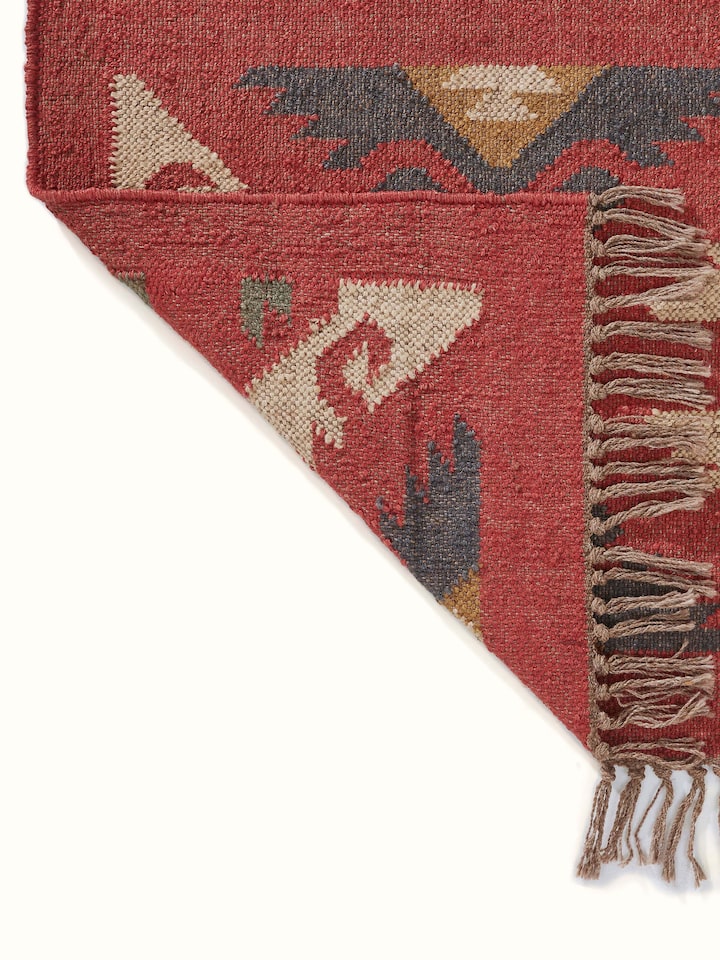 Close-up view of Traditional kilim red lawan wool & jute panja dhurrie showing the detailed design