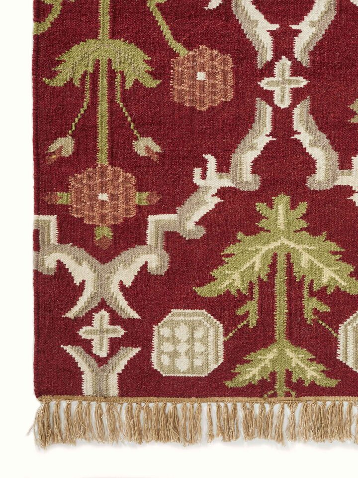 Perspective view of Traditional Mughal Floral Kilim Rust Salawas wool & cotton panja dhurrie showing the overall floral pattern and rust color.