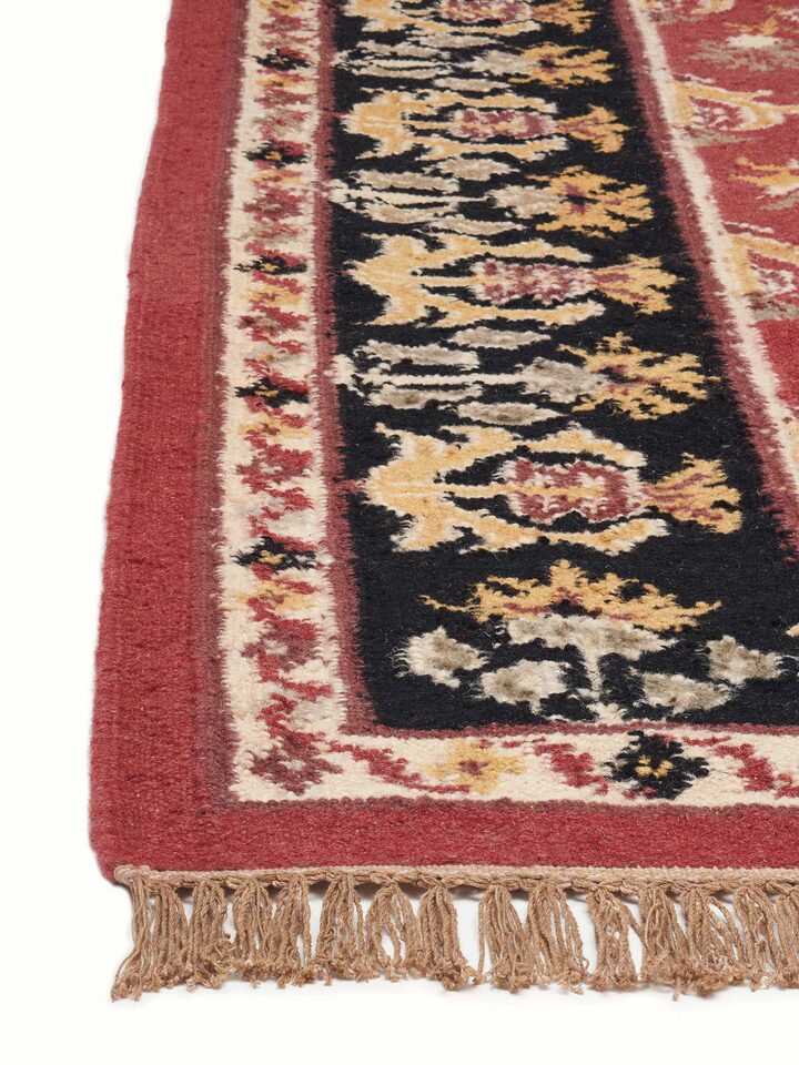 Detailed view of Traditional floral kilim rust salawas wool & cotton panja dhurrie showing the craftsmanship and color contrast