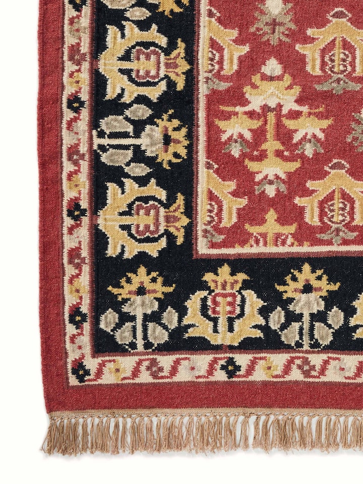 Full view of Traditional floral kilim rust salawas wool & cotton panja dhurrie spread out to display its full pattern